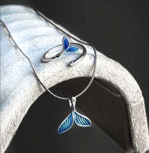 ست دم وال آبی گردنبند و انگشتر فانتزی 🐋 ست دم وال آبی گردنبند و انگشتر فانتزی ✨ معرفی ست دم وال آبی  ست دم وال آبی یک انتخاب خاص و فانتزی برای علاقه‌مندان به زیورآلات متفاوت و طرح‌های الهام‌گرفته از دریا و اقیانوس است. این ست با طراحی زیبای دم وال ، جلوه‌ای متفاوت و چشم‌نواز دارد و می‌تواند استایل شما را خاص‌تر کند. 💙 ترکیب طراحی دریایی، رنگ آبی ، این ست را به گزینه‌ای جذاب برای استفاده روزمره، مهمانی و هدیه دادن تبدیل کرده است. ⭐ ویژگی‌های ست دم وال آبی ✅ طراحی فانتزی و خاص طرح دم وال ✅ زنجیر از جنس استیل رنگ ثابت ✅ پلاک با آبکاری رادیوم ✅ انگشتر فری‌سایز و قابل تنظیم ✅ مناسب برای استفاده روزمره و استایل‌های فانتزی ✅ انتخابی مناسب برای هدیه 💍 انگشتر فری‌سایز انگشتر این ست به صورت باز و قابل تنظیم طراحی شده است و می‌توانید اندازه آن را متناسب با انگشت خود تغییر دهید. این ویژگی باعث می‌شود انتخاب این ست برای هدیه دادن نیز راحت‌تر باشد؛ زیرا نیازی به دانستن سایز دقیق انگشتر ندارید. 📌 مشخصات فنی نام محصول: ست دم وال آبی  طرح: دم وال نوع: ست زیورآلات فانتزی جنس زنجیر: استیل رنگ ثابت آبکاری پلاک: رادیوم انگشتر: فری‌سایز و قابل تنظیم رنگ : آبی مناسب برای: استفاده روزمره، استایل فانتزی و هدیه 💙 چرا ست دم وال آبی را انتخاب کنیم؟ اگر به دنبال یک زیورآلات فانتزی، خاص و متفاوت هستید، ست دم وال آبی می‌تواند انتخاب جذابی باشد. طراحی الهام‌گرفته از وال و دریا ، این محصول را از زیورآلات معمولی متمایز می‌کند. همچنین وجود انگشتر فری‌سایز باعث شده این ست برای هدیه دادن گزینه‌ای کاربردی باشد. 🌊 این محصول برای افرادی که به دریا، اقیانوس، موجودات دریایی و زیورآلات فانتزی علاقه دارند، انتخابی دوست‌داشتنی است. 🎁 مناسب برای هدیه ست دم وال آبی می‌تواند برای مناسبت‌های مختلف به‌عنوان هدیه‌ای خاص استفاده شود: 🎂 هدیه تولد 💕 هدیه برای دوست و عزیزان 🎁 هدیه مناسبتی 💙 هدیه برای علاقه‌مندان به دریا و طرح‌های دریایی ✨ هدیه دخترانه و فانتزی 🛍️ خرید از خرازی آرامیس در خرازی آرامیس می‌توانید انواع زیورآلات فانتزی، گردنبند، انگشتر، اکسسوری، بدلیجات، لوازم ساخت زیورآلات و محصولات خاص را تهیه کنید. برای مشاهده محصولات جدید، اطلاع از موجودی و دریافت کد رهگیری مرسوله‌های ارسالی، عضو کانال ایتای خرازی آرامیس شوید: 📢 کانال محصولات جدید و اطلاع از موجودی: https://eitaa.com/kharraziaramis 🔍 کلمات کلیدی  ست دم وال آبی، ست وال شب تاب، ست دم وال شب تاب، گردنبند دم وال، گردنبند وال آبی، گردنبند طرح وال، گردنبند شب تاب، گردنبند شب تاب آبی، پلاک دم وال، پلاک وال، پلاک وال آبی، پلاک طرح نهنگ، زیورآلات طرح وال، زیورآلات دریایی، زیورآلات فانتزی، انگشتر دم وال، انگشتر وال، انگشتر فری سایز، انگشتر قابل تنظیم، ست گردنبند و انگشتر، گردنبند استیل رنگ ثابت، زنجیر استیل رنگ ثابت، پلاک آبکاری رادیوم، گردنبند دخترانه فانتزی، اکسسوری دخترانه، بدلیجات فانتزی، هدیه دخترانه، هدیه خاص، خرید ست زیورآلات، خرید گردنبند وال، خرید گردنبند شب تاب، قیمت گردنبند شب تاب، خرازی آرامیس، خرازی ارامیس، خرازی آنلاین، خرازی اینترنتی، خرازی قم، خرازی بدلیجات، لوازم زیورآلات، فروشگاه خرازی قم، خرید لوازم خرازی قم، خرازی انلاین قم، اکسسوری آنلاین، اکسسوری اینترنتی، خرازی عمده.